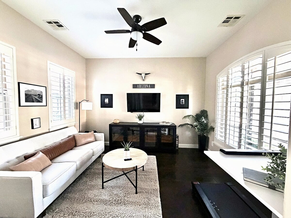 Private lounge with TV + sleeper sofa, plantation shutters & workspace.