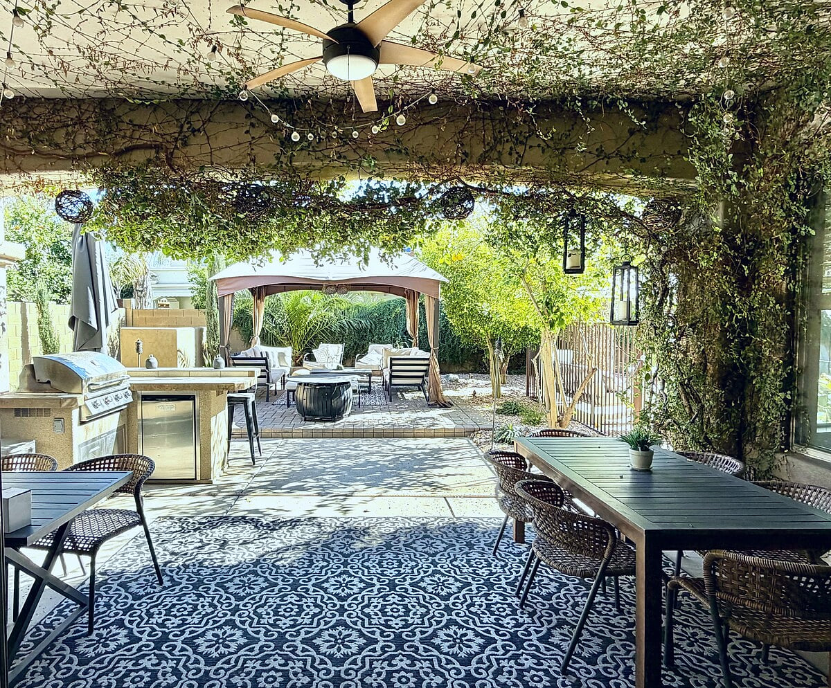 Private resort-style patio with a built-in BBQ, covered dining area, string lights, and a comfy cabana lounge setup. Perfect for alfresco meals, hangouts, and evenings under the twinkle lights.