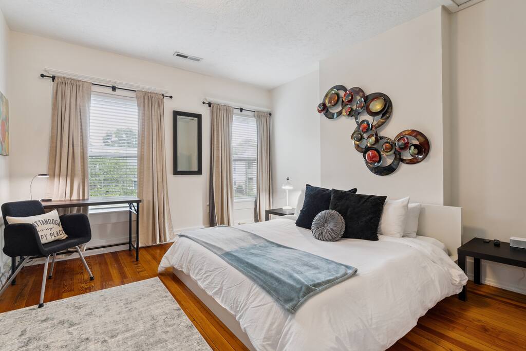 This bright and spacious upstairs bedroom features a luxurious king-sized bed, vibrant decor, and a dedicated workspace—perfect for rest and recharge between Chattanooga outings This bright and spacious upstairs bedroom features a luxurious king-sized bed, vibrant decor, and a dedicated workspace—perfect for rest and recharge between Chattanooga outings - In Southside | Roomy 6 Bedroom | Walk to Choo Choo - Chattanooga
