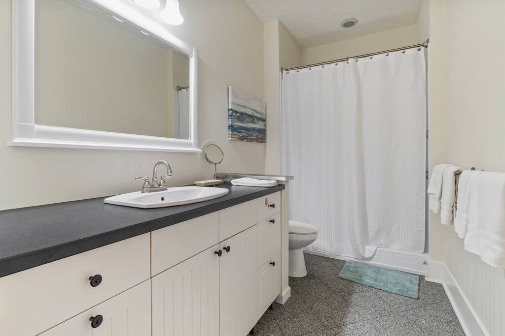 This spacious bathroom features a walk-in shower, ample vanity room, soft lighting, and a clean, coastal-inspired design. This spacious bathroom features a walk-in shower, ample vanity room, soft lighting, and a clean, coastal-inspired design. - In Southside | Roomy 6 Bedroom | Walk to Choo Choo - Chattanooga