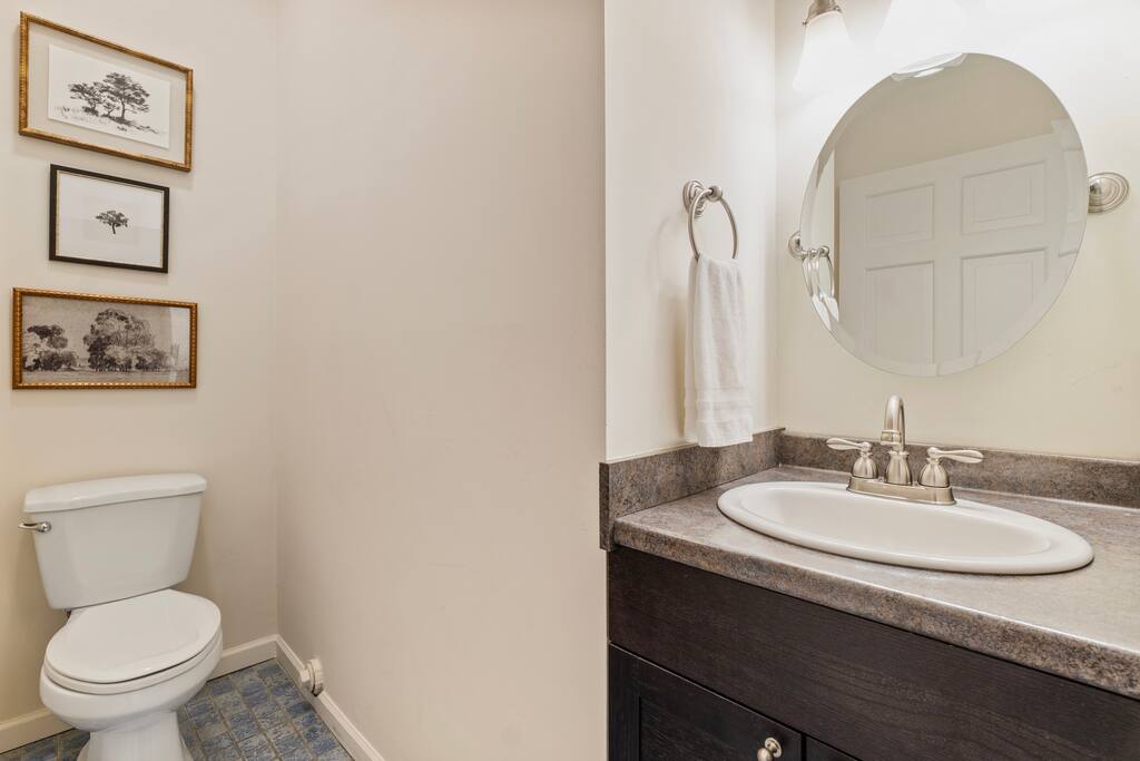 This charming half-bath features a sleek vanity, warm lighting, and classic wall art for a cozy, polished feel. This charming half-bath features a sleek vanity, warm lighting, and classic wall art for a cozy, polished feel. - In Southside | Roomy 6 Bedroom | Walk to Choo Choo - Chattanooga
