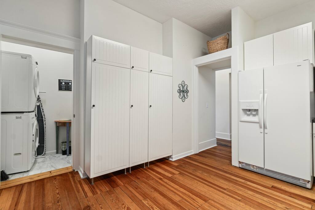The downstairs laundry room includes a stacked washer and dryer, ironing essentials, and a playful laundry sign to keep things light and easy! The downstairs laundry room includes a stacked washer and dryer, ironing essentials, and a playful laundry sign to keep things light and easy! - In Southside | Roomy 6 Bedroom | Walk to Choo Choo - Chattanooga