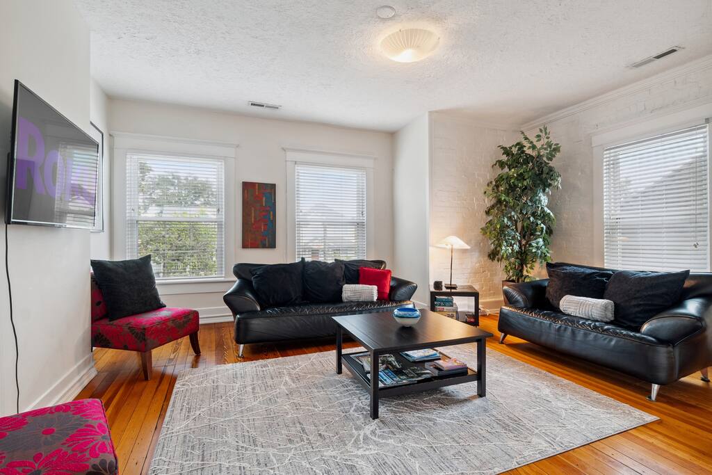 Enjoy the bright and airy upstairs living room, featuring modern leather seating, vibrant decor, and plenty of space to gather, play, or unwind after a day of exploring Chattanooga Enjoy the bright and airy upstairs living room, featuring modern leather seating, vibrant decor, and plenty of space to gather, play, or unwind after a day of exploring Chattanooga - In Southside | Roomy 6 Bedroom | Walk to Choo Choo - Chattanooga