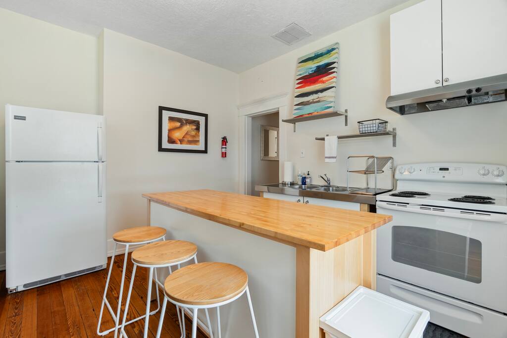 Whether you're brewing coffee or heating up leftovers, the upstairs kitchen has you covered with an island for prep, open shelving, and all the essentials—just no dishwasher Whether you're brewing coffee or heating up leftovers, the upstairs kitchen has you covered with an island for prep, open shelving, and all the essentials—just no dishwasher - In Southside | Roomy 6 Bedroom | Walk to Choo Choo - Chattanooga