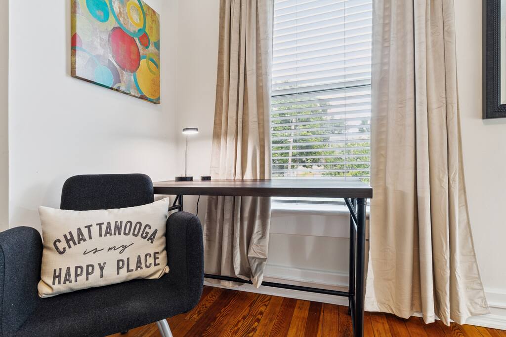 Need to get some work done during your stay? Our cozy corner office features a spacious desk, modern lighting, and a plush chair with a pillow that says it all: "Chattanooga is my happy place." Need to get some work done during your stay? Our cozy corner office features a spacious desk, modern lighting, and a plush chair with a pillow that says it all: "Chattanooga is my happy place." - In Southside | Roomy 6 Bedroom | Walk to Choo Choo - Chattanooga