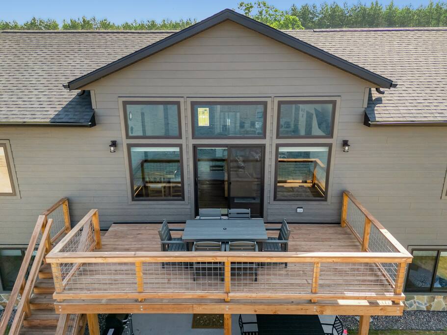 The deck is accessed through the upstairs sliding glass doors. It features a beautiful view of Sunset Lake, an outdoor dining set with 6 chairs and has access down to the patio, firepit area and beach via connected stairs. The deck is accessed through the upstairs sliding glass doors. It features a beautiful view of Sunset Lake, an outdoor dining set with 6 chairs and has access down to the patio, firepit area and beach via connected stairs. - New Listing Lakeside Beach Sleeps 15+ Pet friendly - New Lisbon