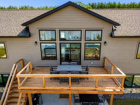 The deck is accessed through the upstairs sliding glass doors. It features a beautiful view of Sunset Lake, an outdoor dining set with 6 chairs and has access down to the patio, firepit area and beach via connected stairs.