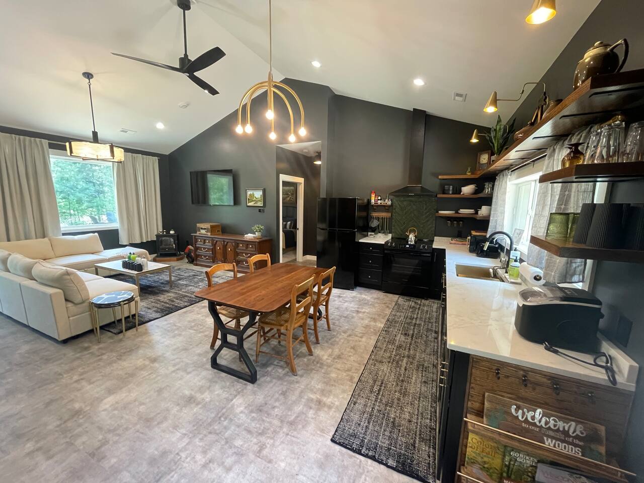 Spacious living room with comfy sectional, smart TV, vintage stereo, and fireplace ambiance—perfect for relaxing or movie nights.