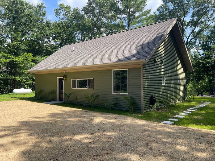 Exterior of home: Front of home with large gravel parking area and stepping stones to the hot tub and backyard. Exterior of home: Front of home with large gravel parking area and stepping stones to the hot tub and backyard. - New Listing 2BR/2BA on Trout Lake HotTub & Firepit - Wisconsin Dells