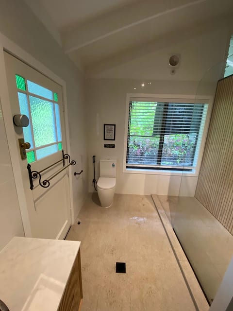Bright spa-like bath with walk-in shower and garden-view window.