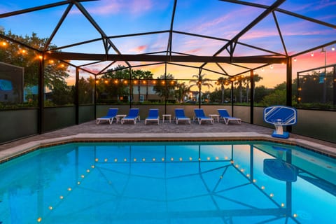 Unwind by the pool at sunset as soft lights glow in the water and patio, creating the perfect twilight retreat to relax and recharge after a fun-filled day at the parks.