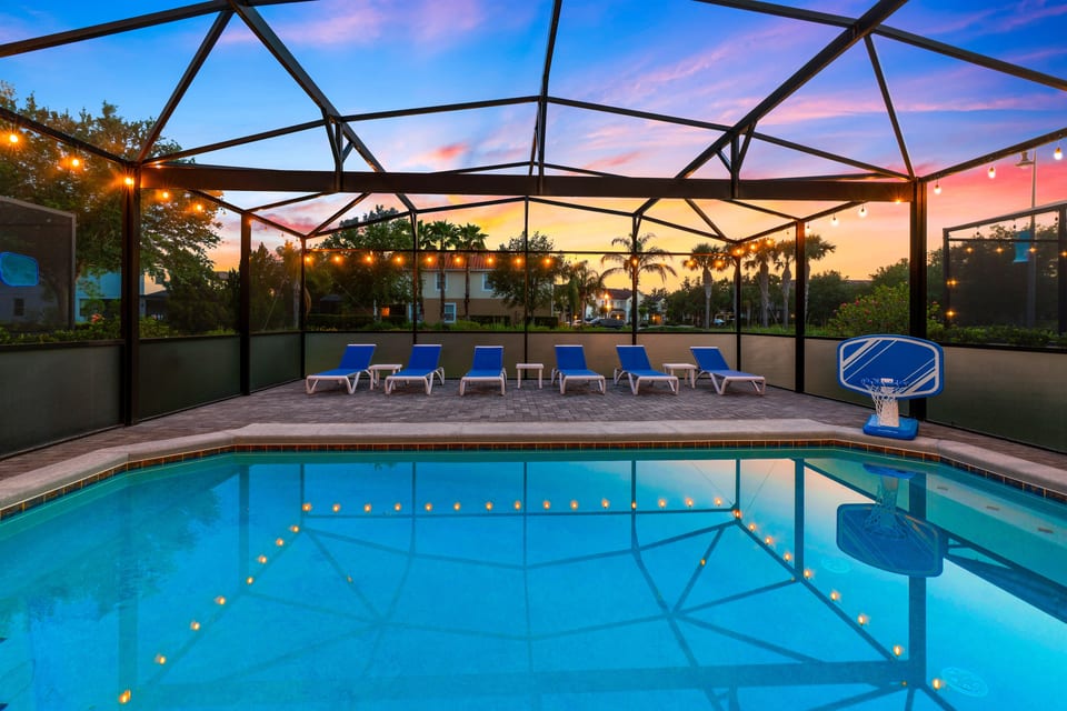 Unwind by the pool at sunset as soft lights glow in the water and patio, creating the perfect twilight retreat to relax and recharge after a fun-filled day at the parks.