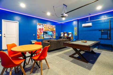Game room features a classic pool table, smart TV, cozy couch, and board games—ideal for family fun and friendly competition.