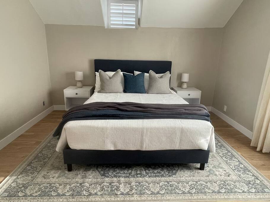 The second bedroom features a comfortable queen-size bed, soft linens, and warm lighting. With simple, modern decor and a peaceful ambiance, it’s a perfect space to relax and recharge during your stay. Ideal for couples or solo travelers