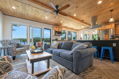 Your retreat begins in a light-filled living room where panoramic water views, warm natural wood, & generous seating invite everyone to settle in, reconnect, & stay awhile. *Now featuring Kuka accent seating in mellow steel blue.*