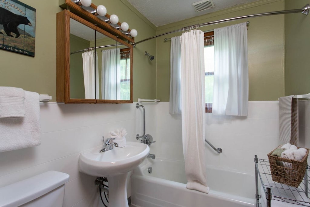 The home has a full bath with a pedestal sink and bathtub/shower combination