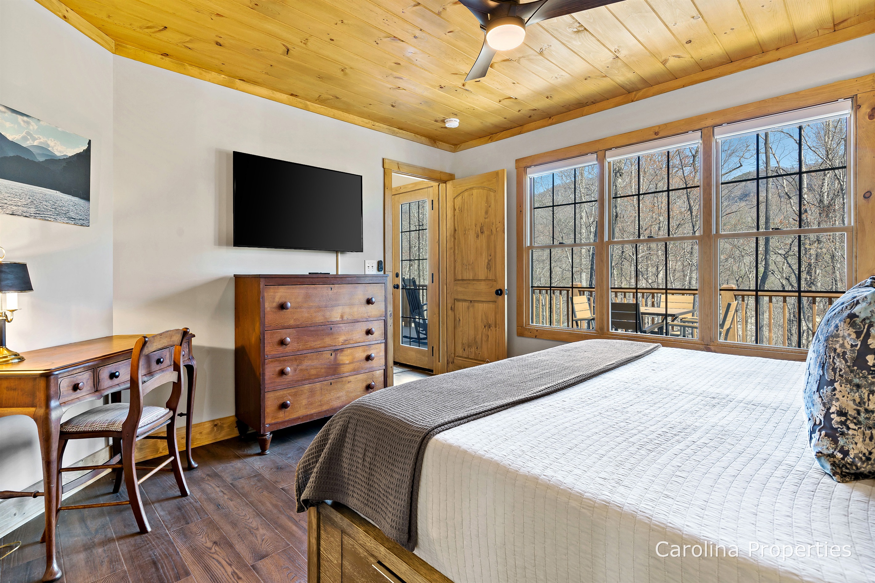 The main level bedroom includes a TV, dresser, and a desk. 