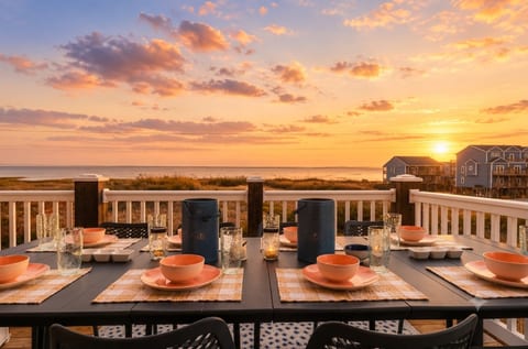 Gather your favorite people for an alfresco dinner on the deck as the sky transforms into a vibrant canvas of violet and gold over the ocean. This inviting setup at Cushy Coast House offers the perfect backdrop for lingering conversations.
