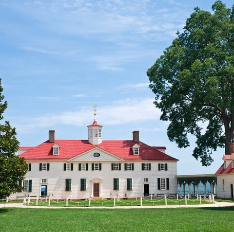 Stately historic estate with sweeping lawn and iconic red roof charm