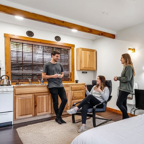 Sunny studio with wood-accented kitchenette and cozy lounge area.