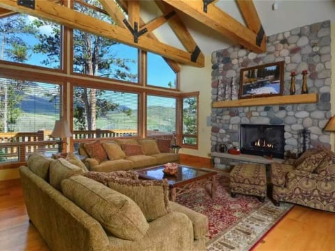 River stone gas fireplace and views from the comfortable living room couches