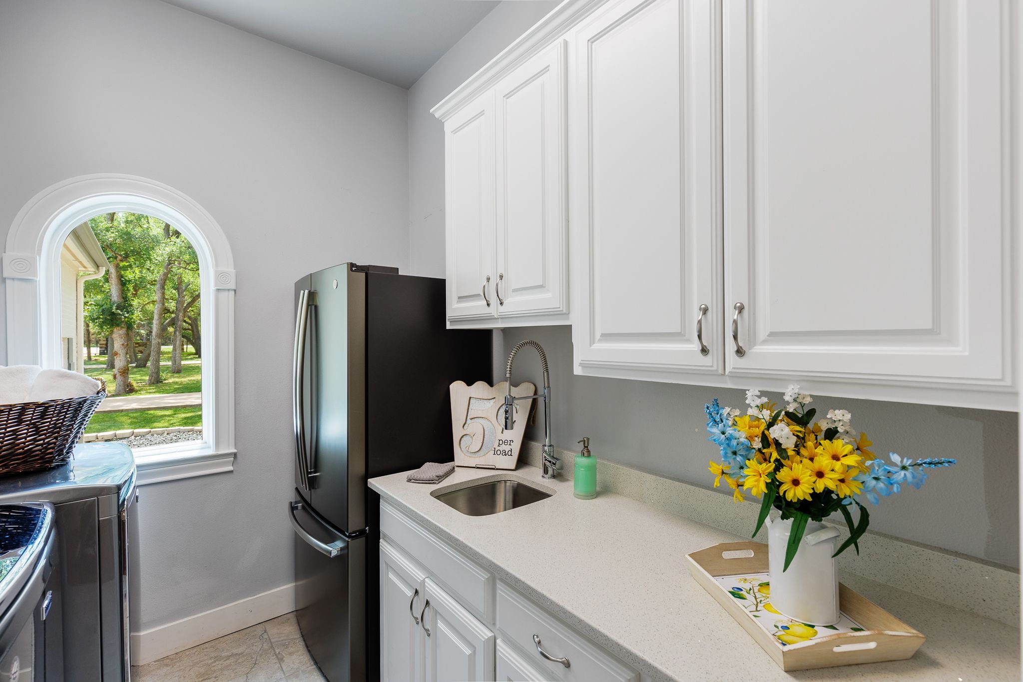 Laundry room in the main house with full size refrigerator, commercial washer and dryer 