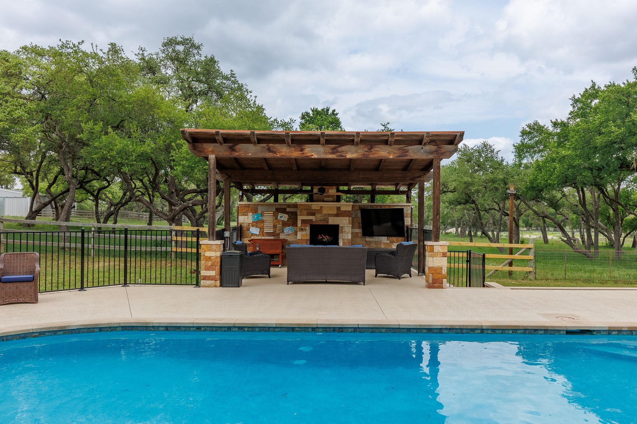 Pool cabana with outdoor tv, rolling beverage cooler, yard games, comfortable couch and chairs