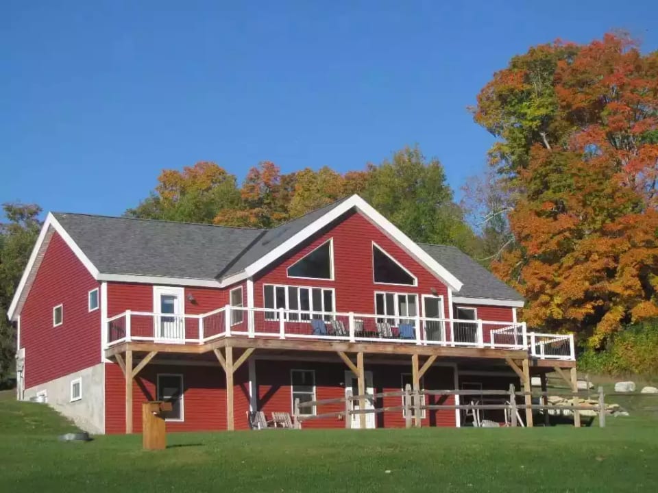 the view of the front of the home with the wrap around deck!
