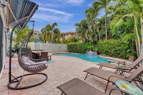 Back patio and pool area with dining table and sunbeds