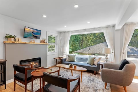 - Bright living room with large picture window views
- Comfortable seating around the cozy fireplace
- Modern décor with natural light for gatherings