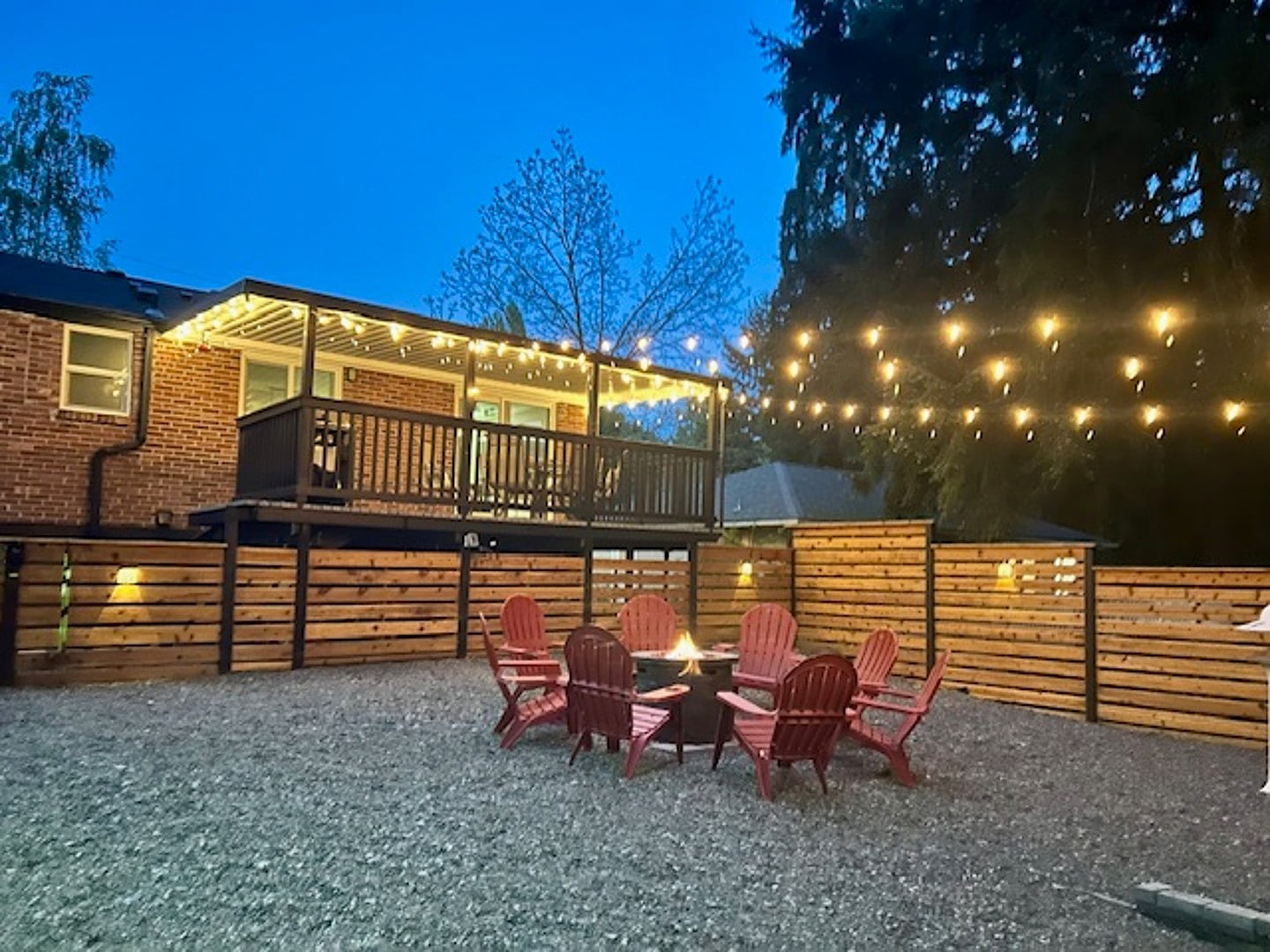 - Outdoor fire pit with Adirondack chairs under lights  
- Deck and patio create cozy evening gathering spaces  
- Perfect for relaxing nights in a private backyard  