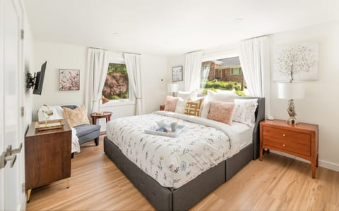 Spacious master bedroom with a king-sized bed, memory foam hybrid mattress, and a cozy reading nook