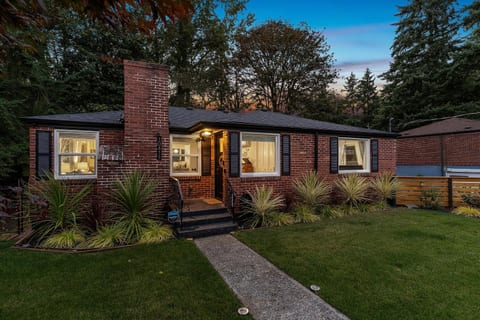 - Stunning evening view of brick home with warm lighting
- Inviting exterior and green lawn welcome every guest
- Cozy retreat surrounded by trees and natural beauty