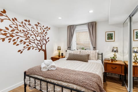 🌿 The Tree Room with queen bed, plush bedding, dual nightstands and a nature inspired statement wall.

