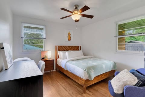 Rest and work effortlessly in this inviting bedroom, featuring a queen bed with beautiful bedding and a dedicated workspace with a desk and chair—perfect for mixing productivity with comfort.