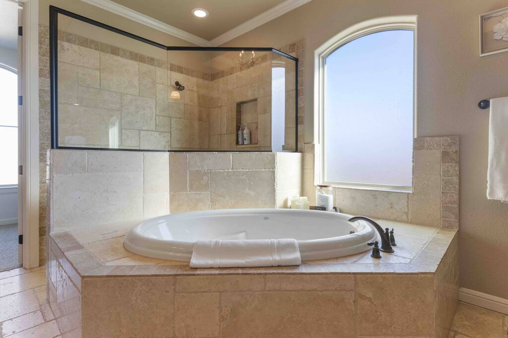 Retreat to your personal spa experience in the master ensuite, where the jacuzzi awaits to melt away the day's stress. - Luxe Retreat: Pool, Hot Tub, Jacuzzi, EV Charger - Granbury