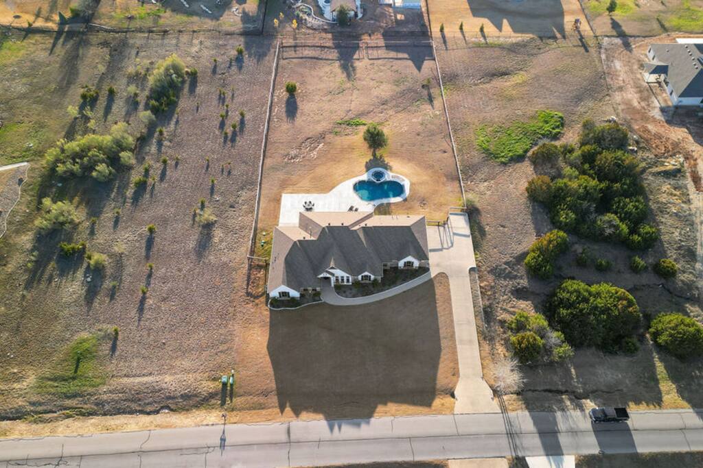 A bird's-eye view of our inviting saltwater pool and spa, promising a private slice of paradise and the ultimate relaxation experience
 - Luxe Retreat: Pool, Hot Tub, Jacuzzi, EV Charger - Granbury