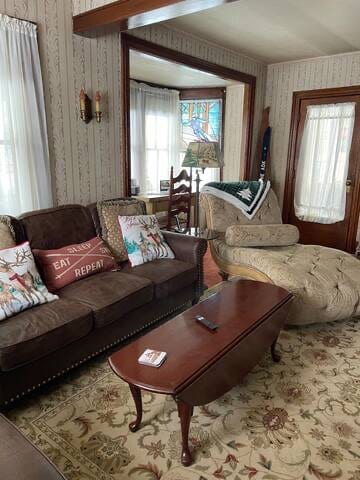 Living room features couch, love seat, chaise lounge, chair and a desk area at the window.