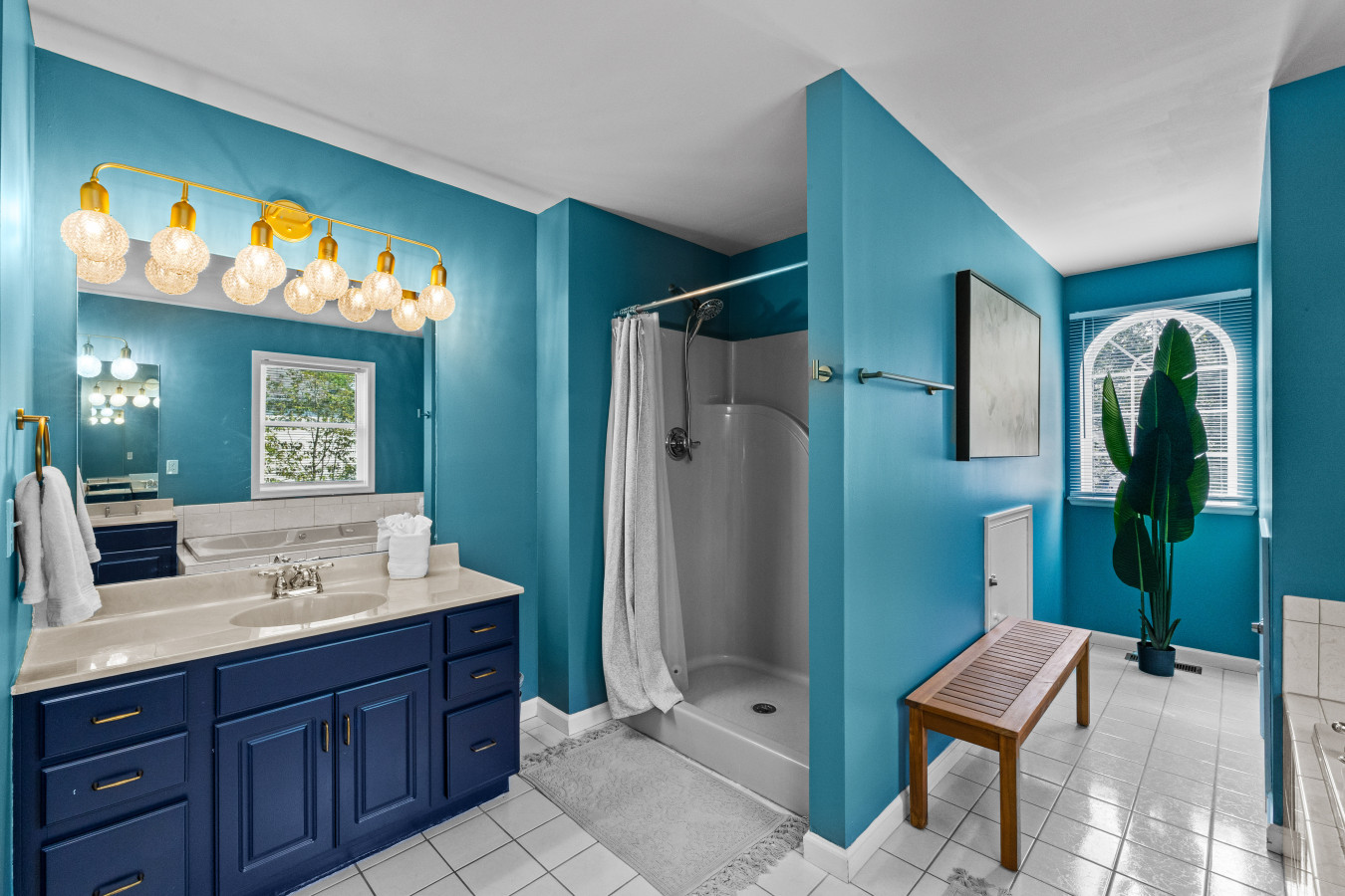 Big sink and mirror, with a perfect spot to sit and unwind next to the tub.