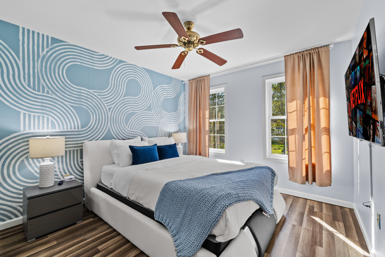 Comfort meets convenience in this cozy second bedroom with a ceiling fan and smart TV.
