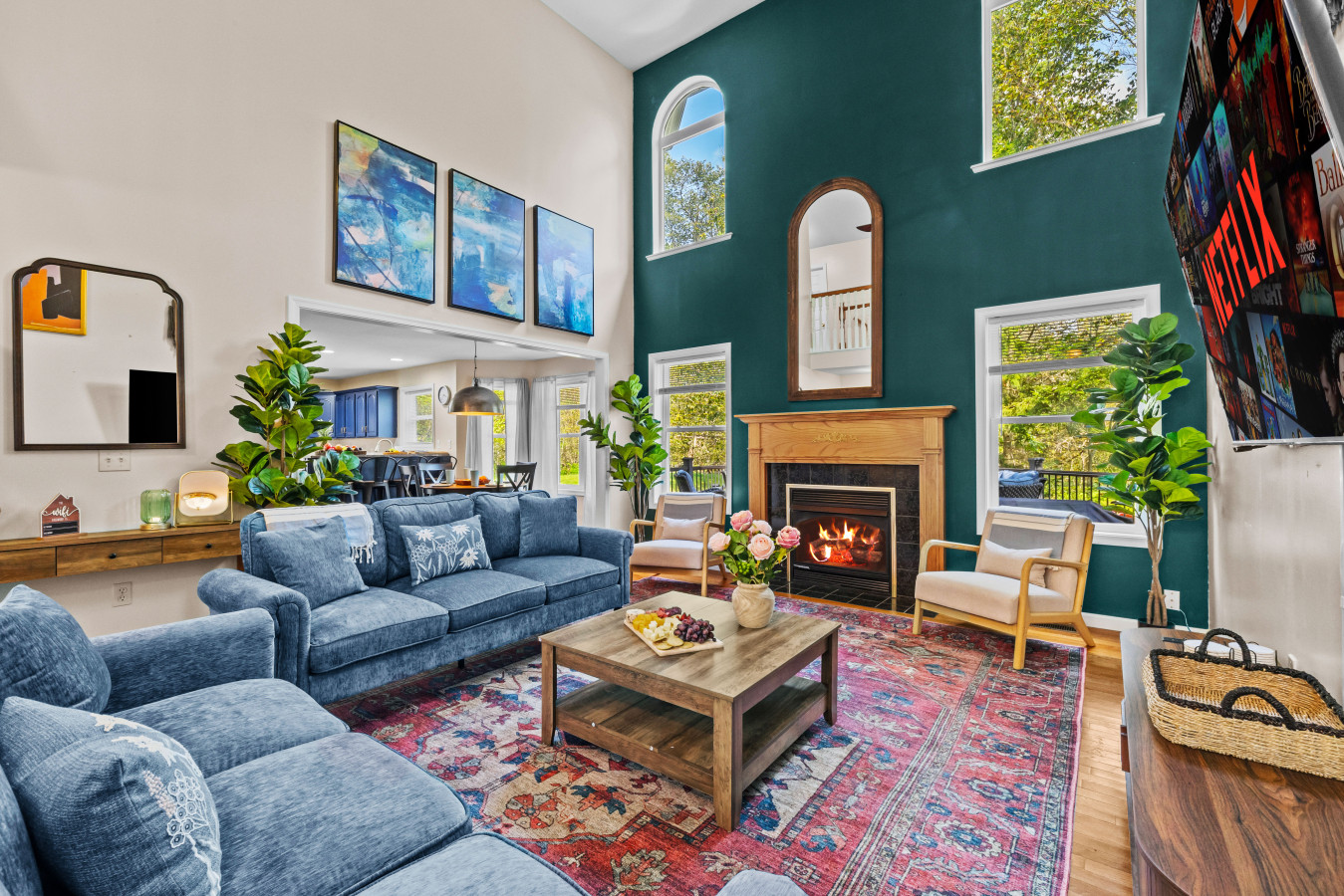 Relax in the cozy Pocono Haven living room — featuring a warm fireplace, smart TV, abundant seating, and sun-filled windows with beautiful natural light.
