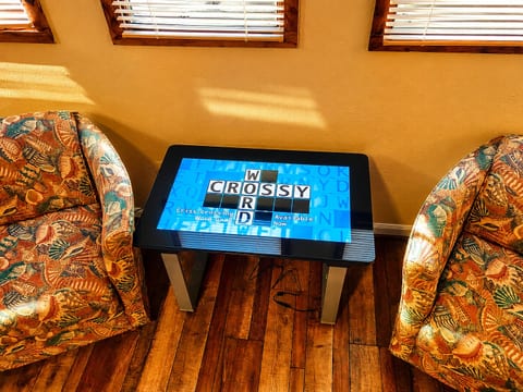 Our Infinity Gaming Table: A highlight for game nights! Enjoy classic games or explore new favorites on this interactive touch-screen table. Tucked against east facing windows, these chairs offer a great spot for morning coffee and a good book