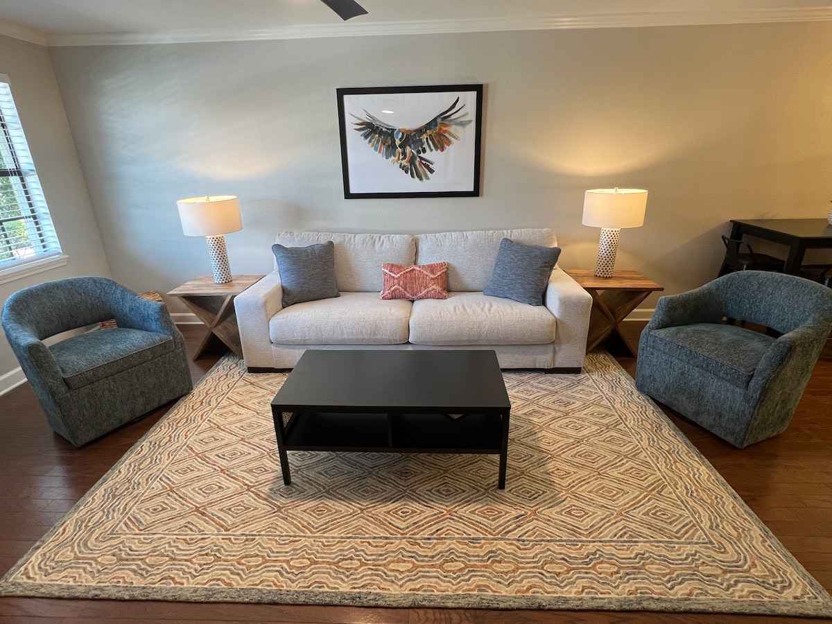 Cozy den with comfy couch and chairs and a Smart TV.