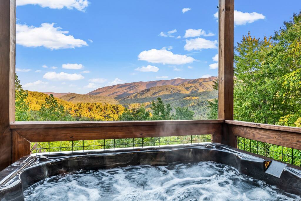 4-5 seat hot tub pressed up against the edge of the deck overlooking a beautiful mountain view