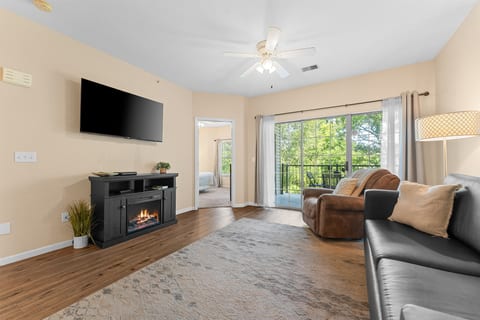 Bright living room with fireplace, big TV, and deck access—an easy place to settle in after a day around Branson.