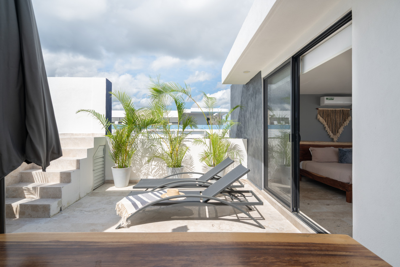 Relax on this modern private terrace featuring a pool, sun loungers, and breakfast area. Enjoy the bright tropical atmosphere and peaceful setting, ideal for morning coffee or afternoon rest.