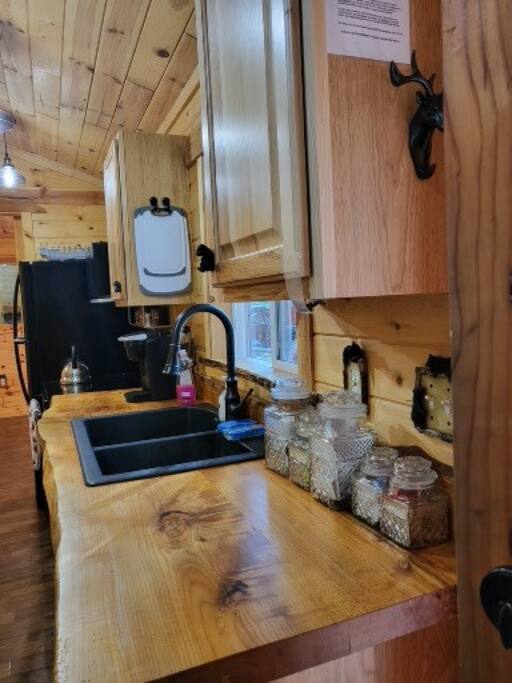 Kitchen has a Keurig coffee maker, full size refrigerator