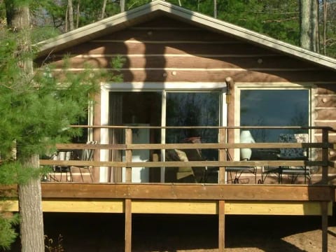 “A quiet glass-front cabin resting above a peaceful bay of Spider Lake, wrapped in pines and stillness.”