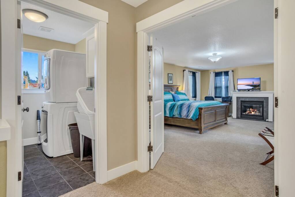 Master bedroom with fireplace and ensuite with view of laundry 