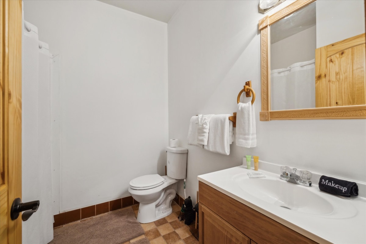 Modern fixtures, warm wood accents, and fluffy towels for a refreshing retreat!